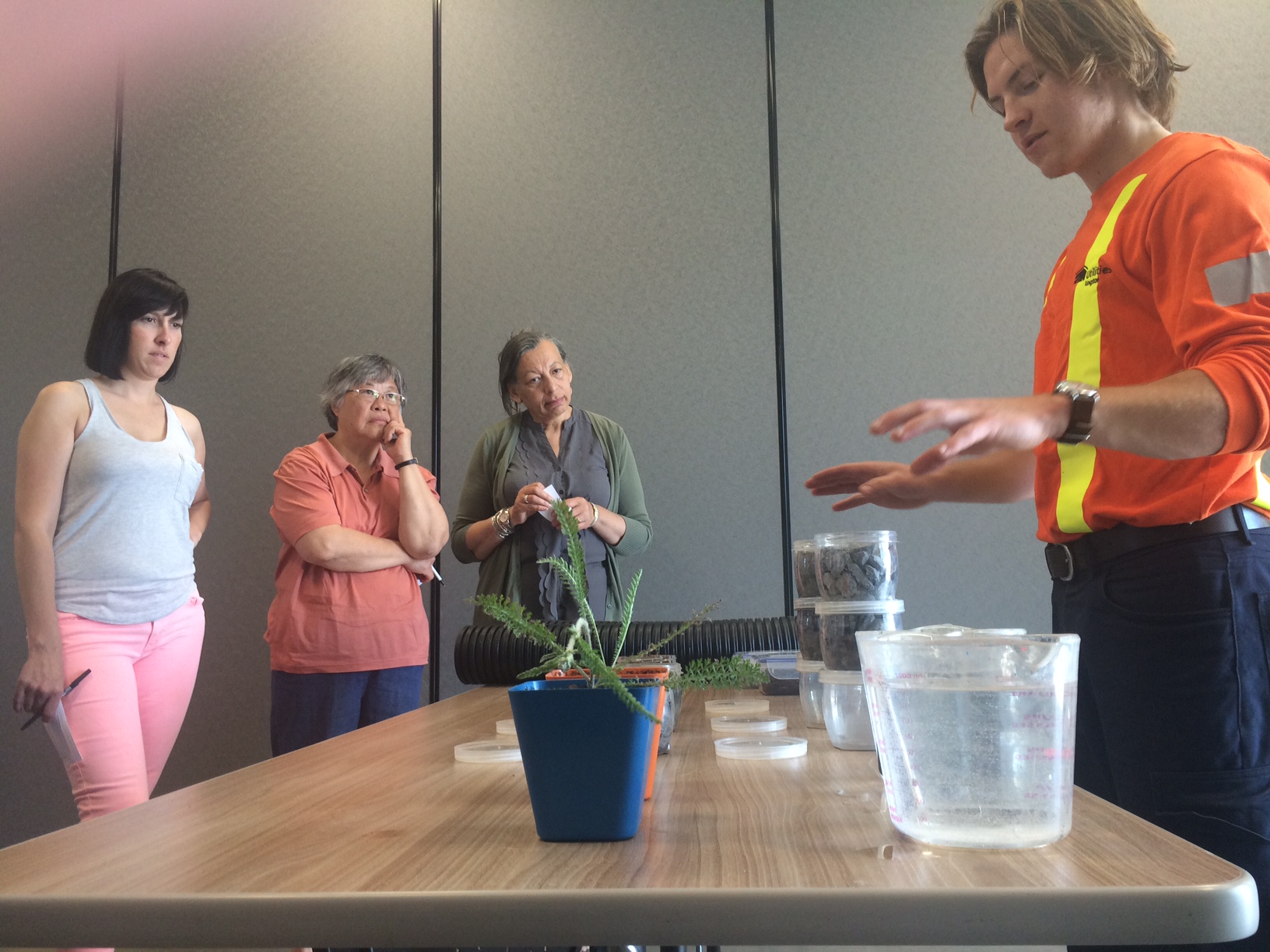 Summer student Keiran Way-Brackenbury demonstrates water wise palnting to home owners