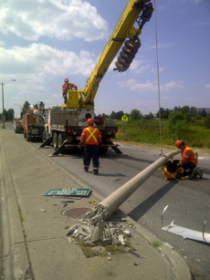 crews replacing a street light pole severed by a motor vehicle accident
